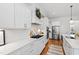 Modern kitchen with white cabinets, stainless steel appliances, and a decorative wreath above the stove at 609 Meyers Place Ln, Holly Springs, NC 27540