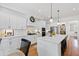 Bright eat-in kitchen boasts white cabinetry, a large island, and stainless steel appliances, ideal for entertaining at 609 Meyers Place Ln, Holly Springs, NC 27540