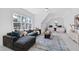 Bright living room featuring large windows, a dark sofa, and a cozy atmosphere at 609 Meyers Place Ln, Holly Springs, NC 27540