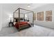This bright bedroom has a four poster bed, ceiling fan and large windows with views of nature at 609 Meyers Place Ln, Holly Springs, NC 27540