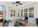 Relaxing screened porch featuring ample seating, string lights, and a peaceful view of the outdoors at 609 Meyers Place Ln, Holly Springs, NC 27540