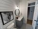 Stylish half bathroom featuring wood plank walls, patterned tile floors, and modern fixtures at 65 Oglethorpe Ave, Clayton, NC 27527