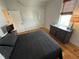 Well-lit bedroom features hardwood floors, neutral walls, and a comfortable bed with dark gray bedding at 65 Oglethorpe Ave, Clayton, NC 27527