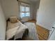 Comfortable bedroom with wood floors, bright natural light, and a small bed with comfy pillows at 65 Oglethorpe Ave, Clayton, NC 27527