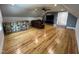 Spacious bonus room with hardwood floors, bar, brown leather couch, TV, and ceiling fan at 65 Oglethorpe Ave, Clayton, NC 27527