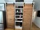 Stylish shelving with wooden sliding doors, decorative items, and adjacent stainless steel refrigerator at 65 Oglethorpe Ave, Clayton, NC 27527