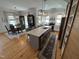 Expansive open-concept kitchen with large island, dining area, stainless appliances, and wooden sliding door cabinet at 65 Oglethorpe Ave, Clayton, NC 27527