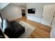 Spacious living room with hardwood floors and neutral walls features a comfortable black leather recliner at 65 Oglethorpe Ave, Clayton, NC 27527