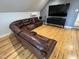 Spacious living room with hardwood floors and neutral walls features a large brown leather sectional sofa at 65 Oglethorpe Ave, Clayton, NC 27527