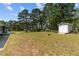 A sprawling backyard with lush grass, storage shed, and views of surrounding woods at 664 Marler Rd, Benson, NC 27504