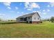 Backyard view showcasing a house with a screened-in porch, brick foundation, and lush lawn at 664 Marler Rd, Benson, NC 27504