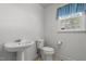 Bathroom with a pedestal sink, toilet, and window at 664 Marler Rd, Benson, NC 27504