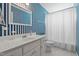 Bathroom featuring blue-striped wallpaper, single sink vanity, and shower tub at 664 Marler Rd, Benson, NC 27504