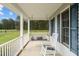 Inviting front porch with a porch swing, rocking chair and a beautiful view of a vast open field at 664 Marler Rd, Benson, NC 27504