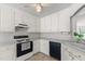 Eat-in kitchen featuring white cabinets, appliances, and a ceiling fan at 664 Marler Rd, Benson, NC 27504