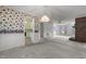 Open concept living room with brick fireplace, floral wallpaper, and view of the eat in kitchen at 664 Marler Rd, Benson, NC 27504