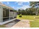 View of a screened porch with concrete patio extending out into a large, grassy yard at 664 Marler Rd, Benson, NC 27504