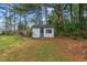 Exterior view of a weathered shed featuring a blue door and surrounded by trees at 664 Marler Rd, Benson, NC 27504