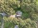 Aerial view of the home showcasing its placement among mature trees, landscaping, and gravel driveway at 707 Sinai Cir, Hillsborough, NC 27278