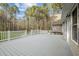Large back deck with white railings overlooks a lush backyard, ideal for entertaining and relaxing in a serene outdoor setting at 707 Sinai Cir, Hillsborough, NC 27278