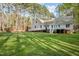 Large, shady backyard features expansive lawn, mature trees, a shed, and house with elevated deck and wheelchair access at 707 Sinai Cir, Hillsborough, NC 27278