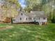 A well-maintained backyard showcases an elevated deck, lush lawn, and an outbuilding for extra storage space at 707 Sinai Cir, Hillsborough, NC 27278