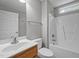 A cozy bathroom features a tub and shower, wooden vanity, toilet and mirror at 707 Sinai Cir, Hillsborough, NC 27278