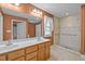 Bathroom with double sink, tile shower, and large mirror with vanity lighting at 707 Sinai Cir, Hillsborough, NC 27278