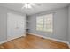 A light-filled bedroom offers hardwood floors, neutral walls, and a window with views at 707 Sinai Cir, Hillsborough, NC 27278