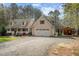 Well-maintained home with an attached garage, gravel driveway, manicured lawn, and a charming outbuilding at 707 Sinai Cir, Hillsborough, NC 27278