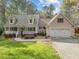 Charming home featuring a welcoming front porch, attached two-car garage, and beautifully landscaped front yard at 707 Sinai Cir, Hillsborough, NC 27278