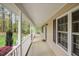 Inviting front porch featuring white columns, views of the front yard, and exterior window shutters at 707 Sinai Cir, Hillsborough, NC 27278