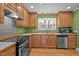 A well-equipped kitchen with stainless steel appliances, wood cabinetry, and a window over the sink at 707 Sinai Cir, Hillsborough, NC 27278