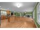 Large open-concept living space including a kitchen, fireplace, bar, and dining area, all with hardwood flooring at 707 Sinai Cir, Hillsborough, NC 27278