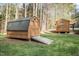 Exterior view of two wooden sheds on a grassy lot, offering convenient storage solutions in a natural, wooded setting at 707 Sinai Cir, Hillsborough, NC 27278