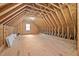 This is an unfinished attic with natural wood and a small window at 707 Sinai Cir, Hillsborough, NC 27278