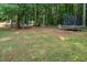 Expansive backyard with mature trees, play equipment, and room for recreational activities at 711 Kentcie Ln, Efland, NC 27243