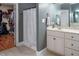 Bathroom with tile floor, gray walls, shower with curtain, white vanity and mirror, with closet in the background at 711 Kentcie Ln, Efland, NC 27243