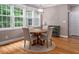 Dining area featuring a wooden table with four chairs, complemented by natural light from large windows at 711 Kentcie Ln, Efland, NC 27243