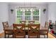 Dining room with large windows providing natural light and a rustic chandelier above wooden table at 711 Kentcie Ln, Efland, NC 27243