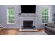 Cozy fireplace with white mantle, flanked by windows and decorative accents for a warm ambiance at 711 Kentcie Ln, Efland, NC 27243