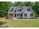 Charming gray two-story home featuring a well-manicured lawn and a welcoming front porch with swing at 711 Kentcie Ln, Efland, NC 27243
