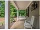 Inviting front porch with white rocking chair and swing, complemented by a unique round window at 711 Kentcie Ln, Efland, NC 27243