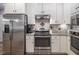 Eat-in kitchen featuring stainless steel appliances, including a refrigerator, stove, and oven, with white cabinets at 711 Kentcie Ln, Efland, NC 27243