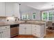 Bright kitchen featuring white cabinets, granite countertops, and stainless steel dishwasher with natural light at 711 Kentcie Ln, Efland, NC 27243