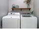 Laundry room featuring white front loading washer and dryer and wooden shelf at 711 Kentcie Ln, Efland, NC 27243