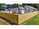 An angled view of the backyard enclosed by a wooden privacy fence and showing the exterior of the home at 815 Goshen St, Oxford, NC 27565