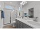 This spacious bathroom includes double sinks with gray cabinets and a glass-enclosed shower at 815 Goshen St, Oxford, NC 27565