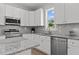 Close-up of a contemporary kitchen featuring granite countertops, stainless steel appliances, and sleek white cabinetry at 815 Goshen St, Oxford, NC 27565
