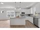 Open kitchen with a center island, stainless appliances, white cabinets, and granite countertops at 815 Goshen St, Oxford, NC 27565